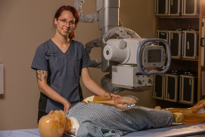 An X-ray technology student practices on a medical dummy