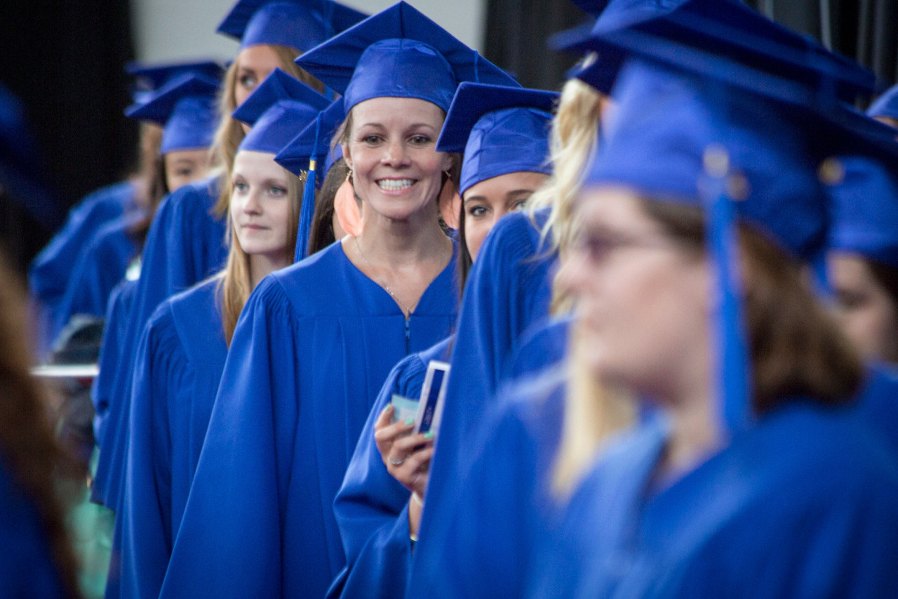 A row of students early wait to cross the stage at convocation