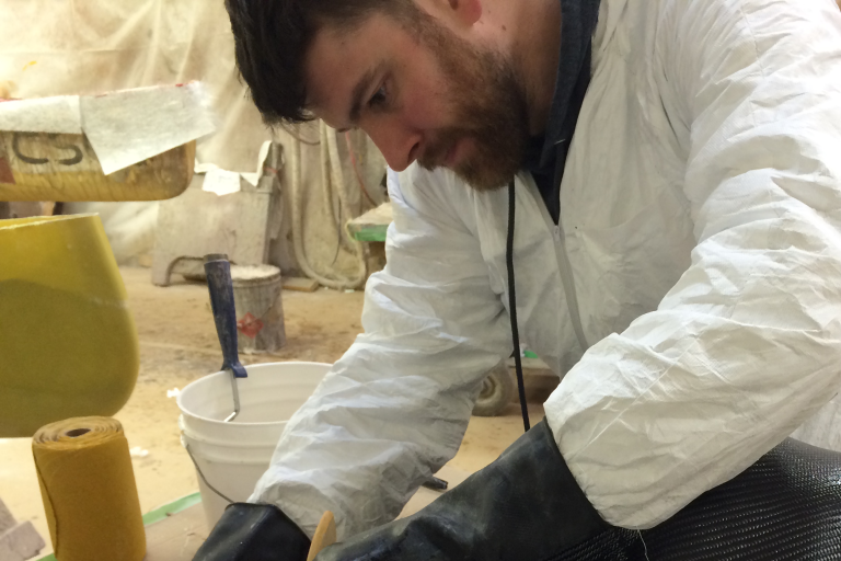 Man wearing white industrial coveralls while working. 