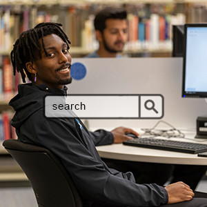 Student at computer station in Interurban Library searching online with overlay bar showing new appearance of the tool an rounded rectangle that reads "Search" with a magnifier icon 