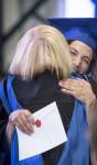 Faculty hugging student at graduation ceremony