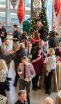 An overhead shot of a large holiday party in a light filled atrium space