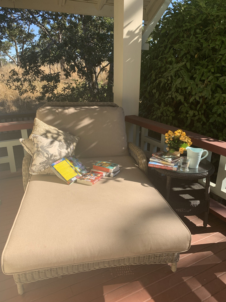 Photograph of a comfortable chair to read with books.