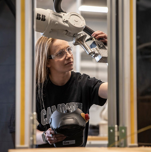 Mechanical Engineering Technology students works with a large laser. 