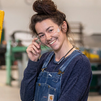 Studnt Morganna Sampson working in the metal shop