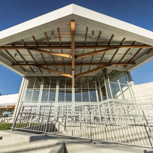 The outside of an impressive, glass and timber building. 