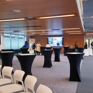 A reception hall set up with cocktail tables and a ceremony area.