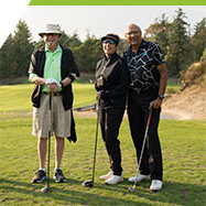 three golfers posing for photo on golf course fairway on sunny day