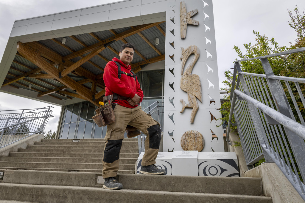 Jason Provencher standing next to the 50th Anniversary House Post outside the CTEI Building.