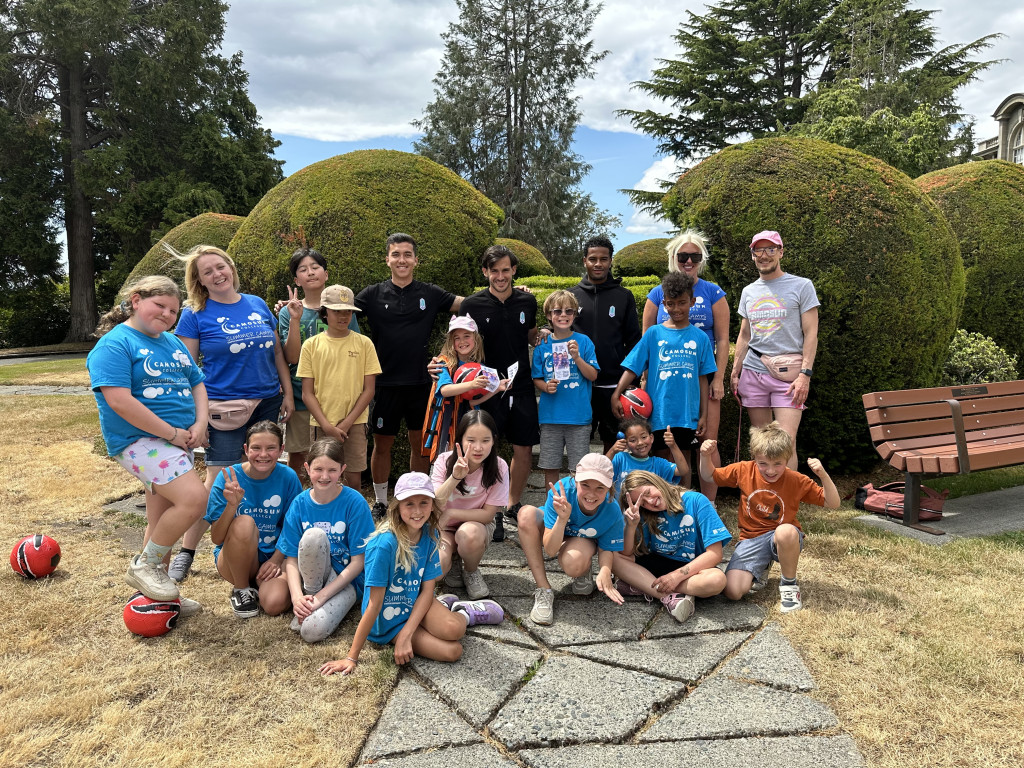 Kids posing with Pacific Football Club players during Camosun's Summer Sports Camp