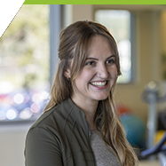 Sarah smiling in an Athletic Exercise Therapy room. 