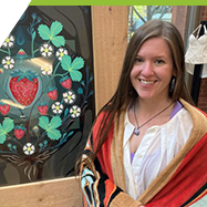 Alisha Parks, standing beside her artwork, "Gifts of the Heartberry"