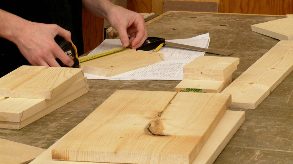 a carpenter measures a piece of wood