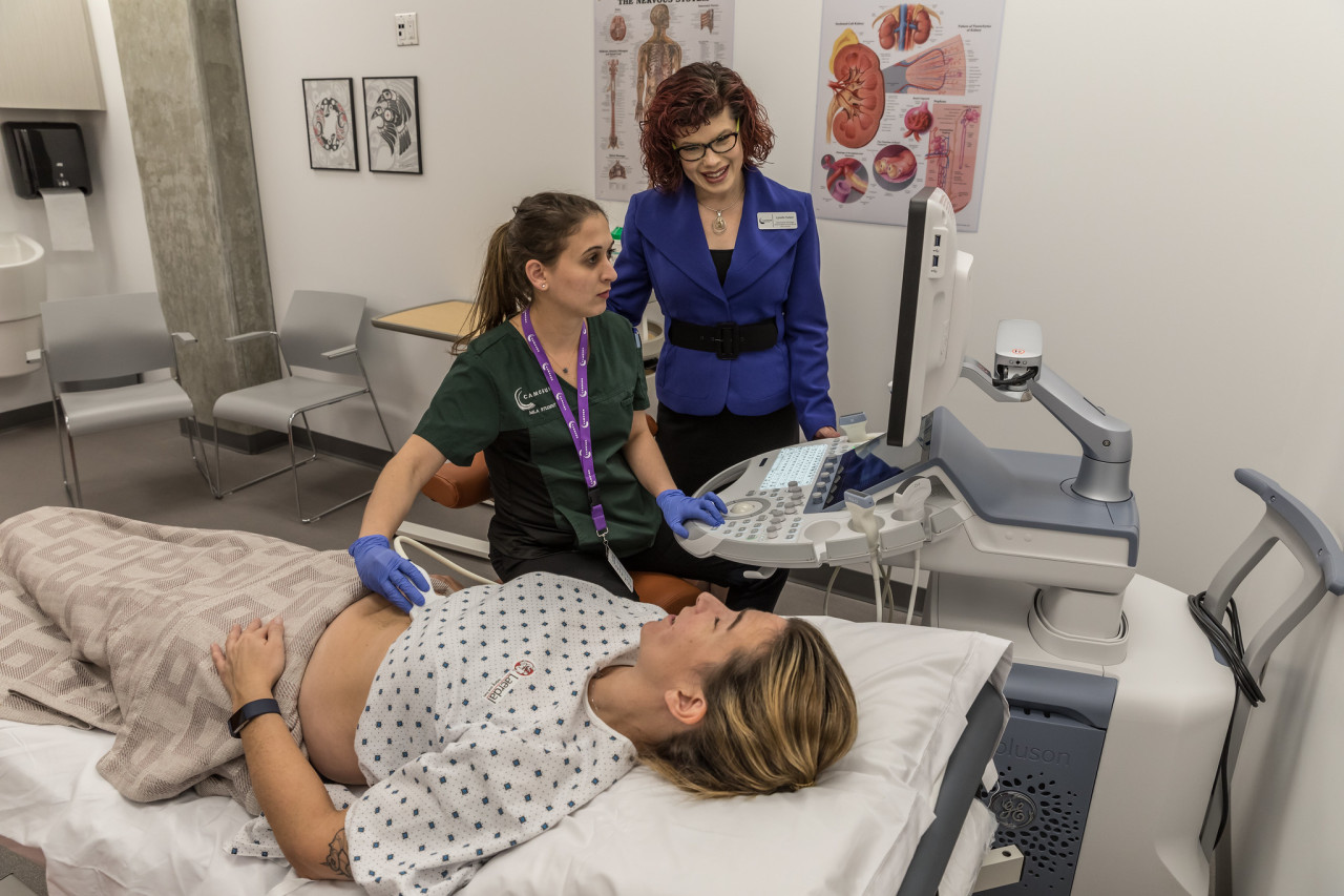 A sonography practices taking a scan on a patient 