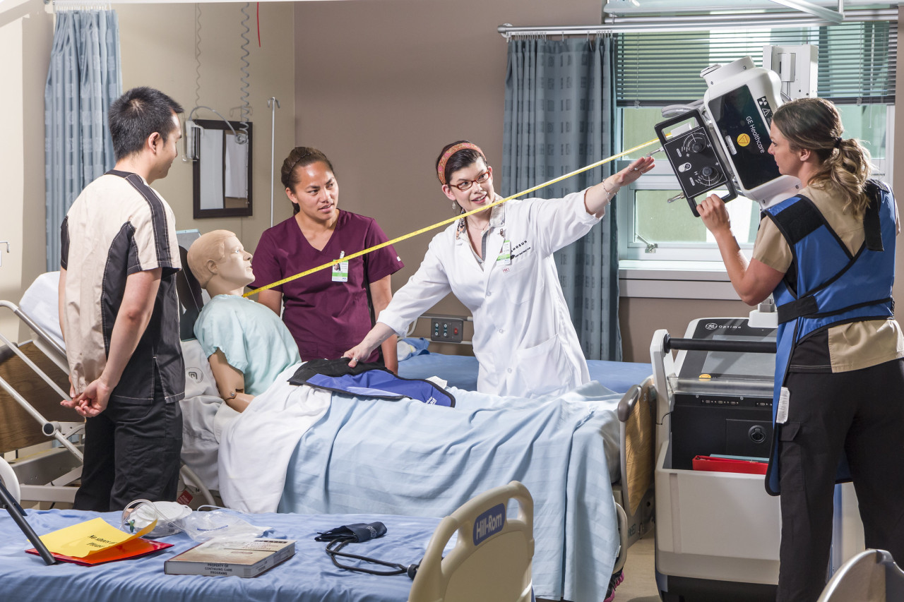 A teacher demonstrates the ideal distance between a patient and an x-ray machine