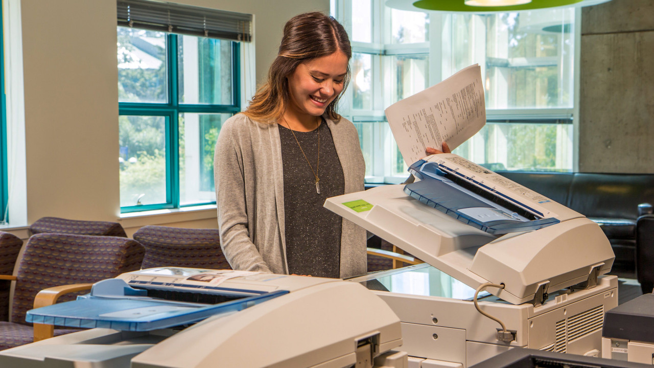 a student uses a photocopier in the Library