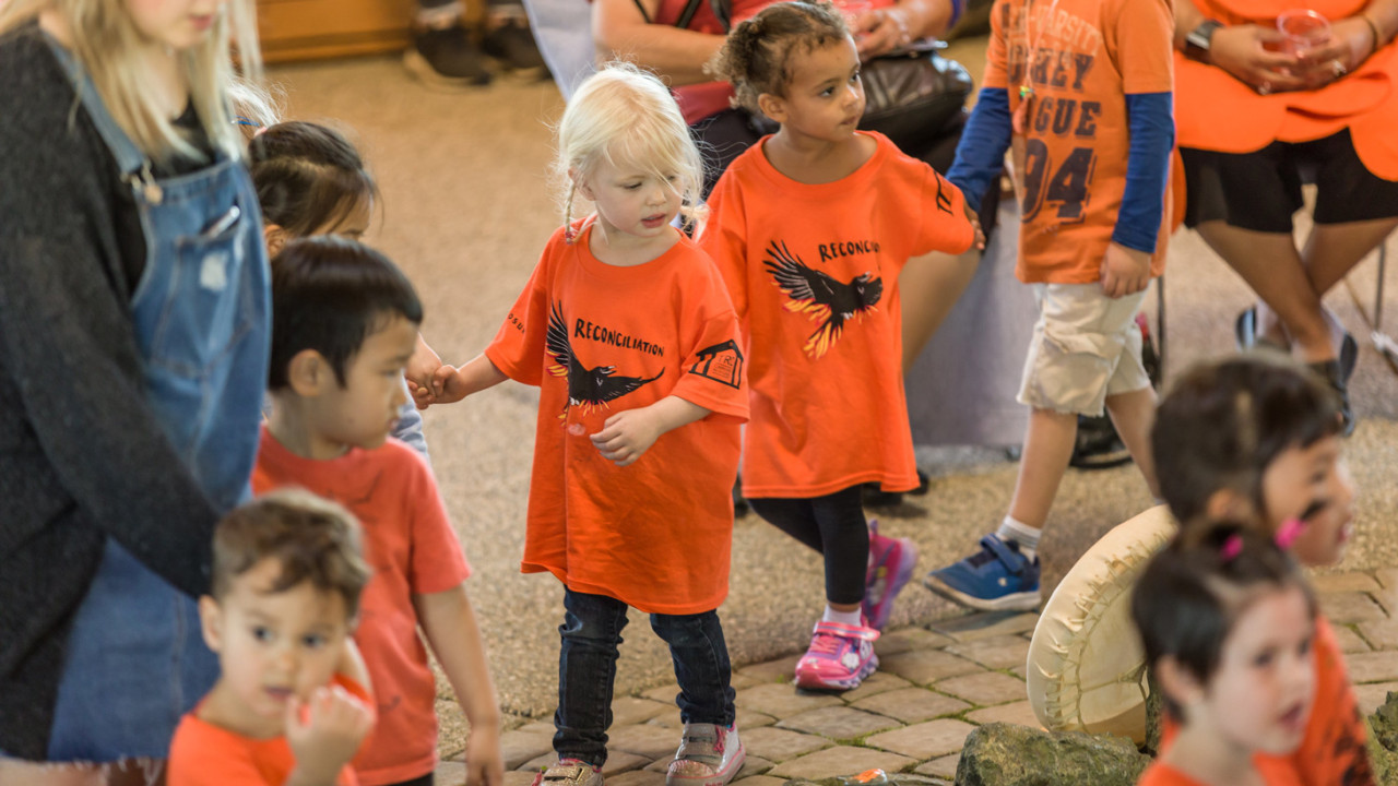 a group of kids from the child care center on campus take part in Orange shirt day 