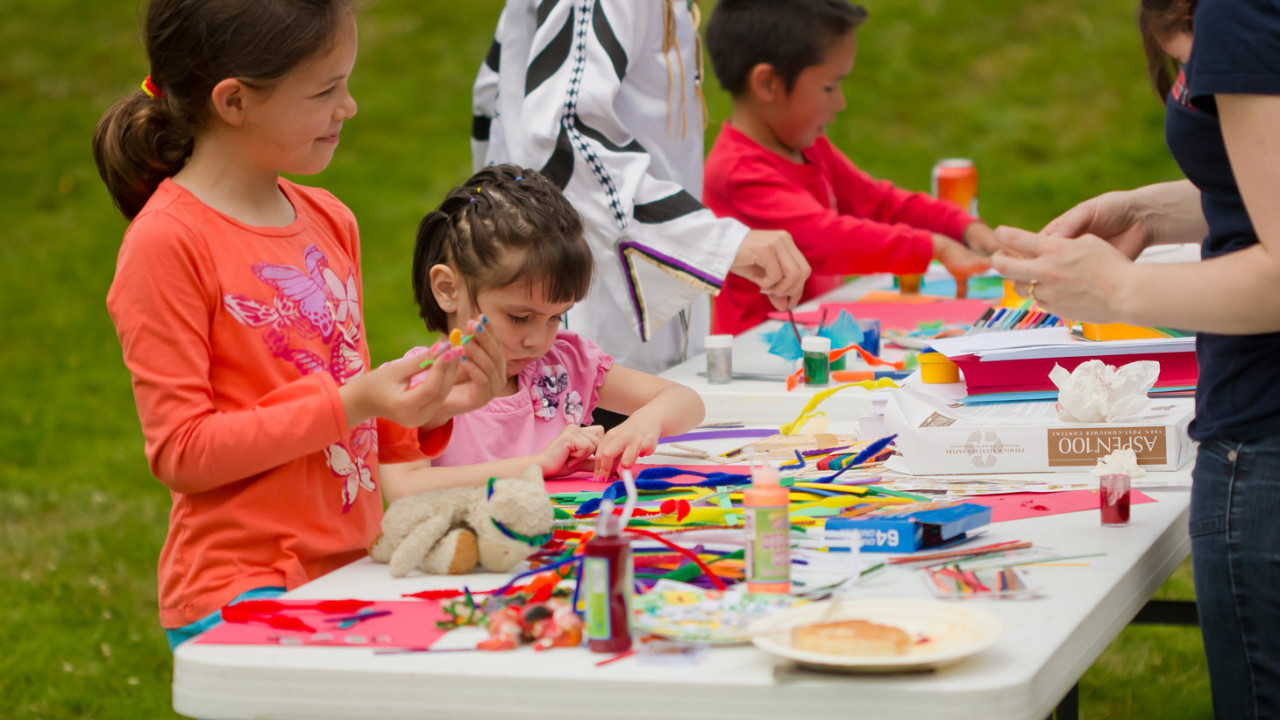 Kids playing at an outdoor craft table 