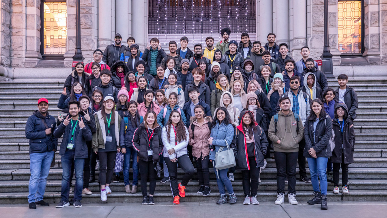 A group of International students poses in front of the BC parliament building