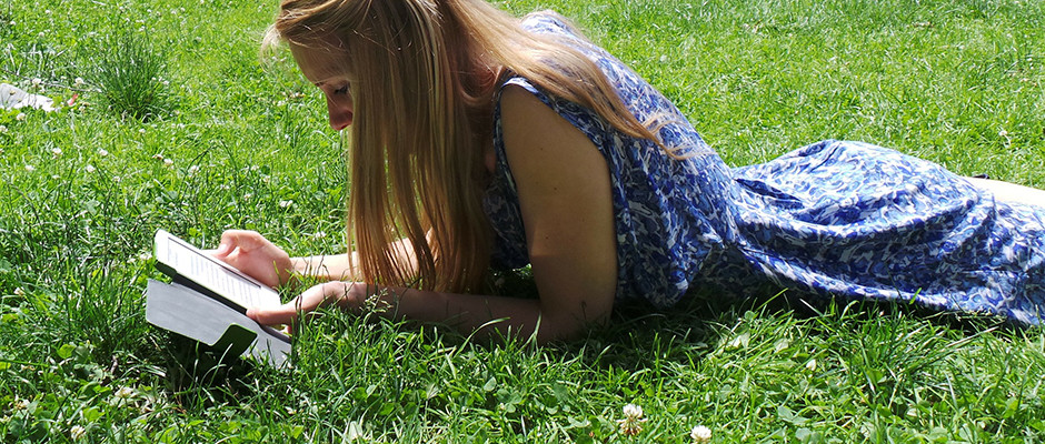 student reading outside on grass