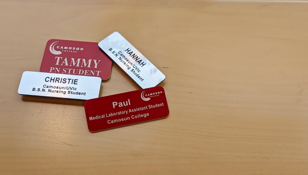 4 name tags in a pile on a table