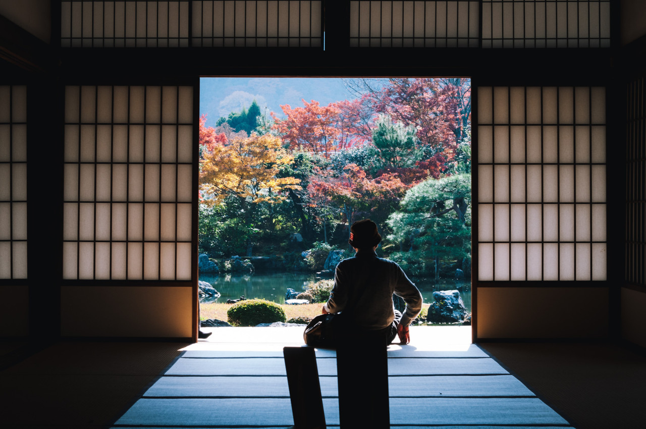 Silhouette of man sitting inside a Japanese temple