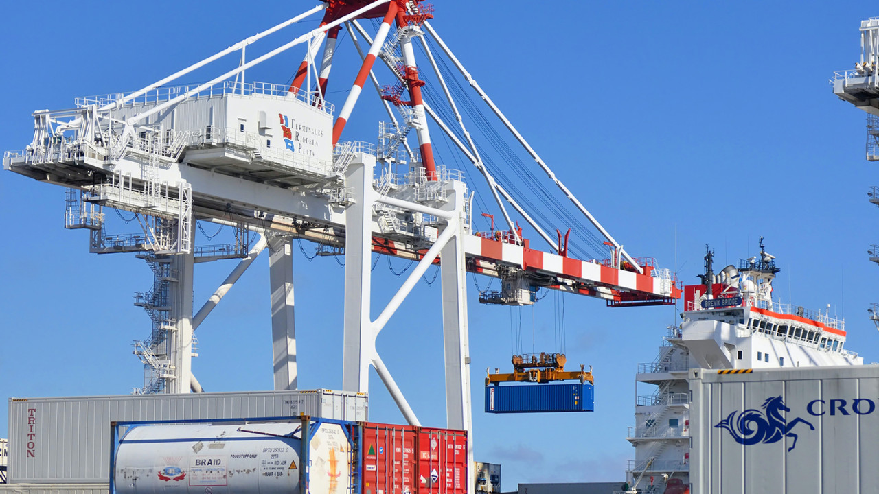 Crane in a shipyard listing shipping containers