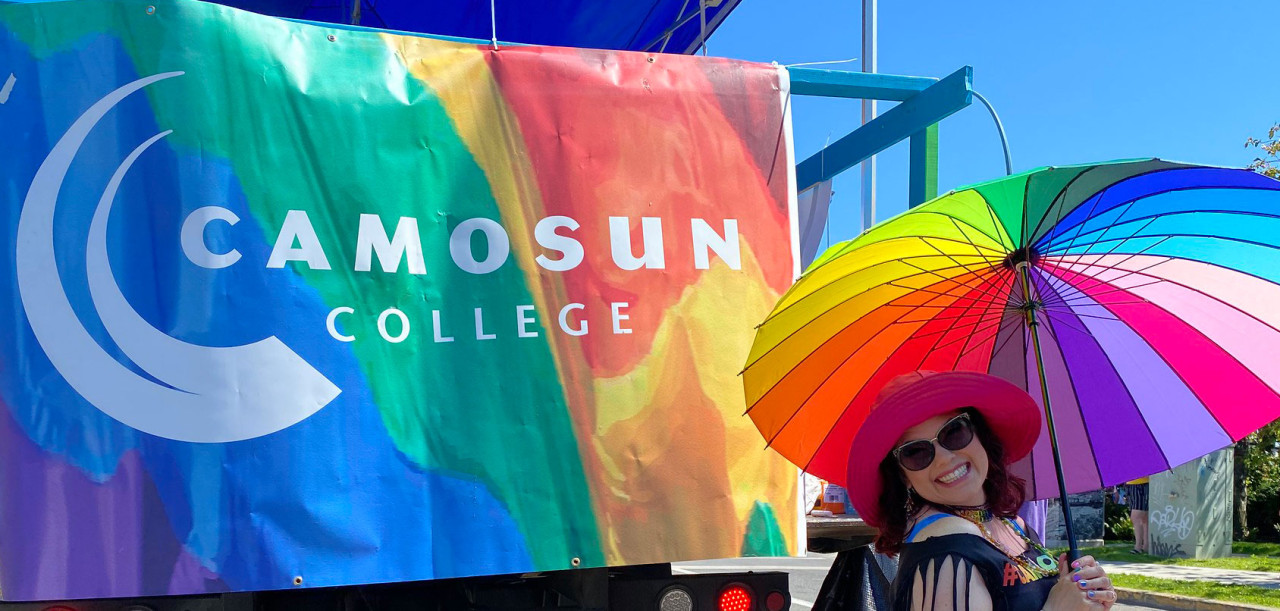 camosun banner and a person with a rainbow coloured umbrella