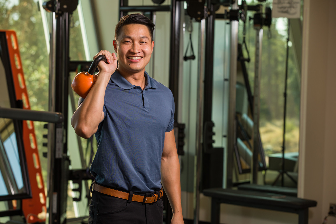 athletic therapist posing with orange kettle bell in the aet clinic at camosun college interurban campus