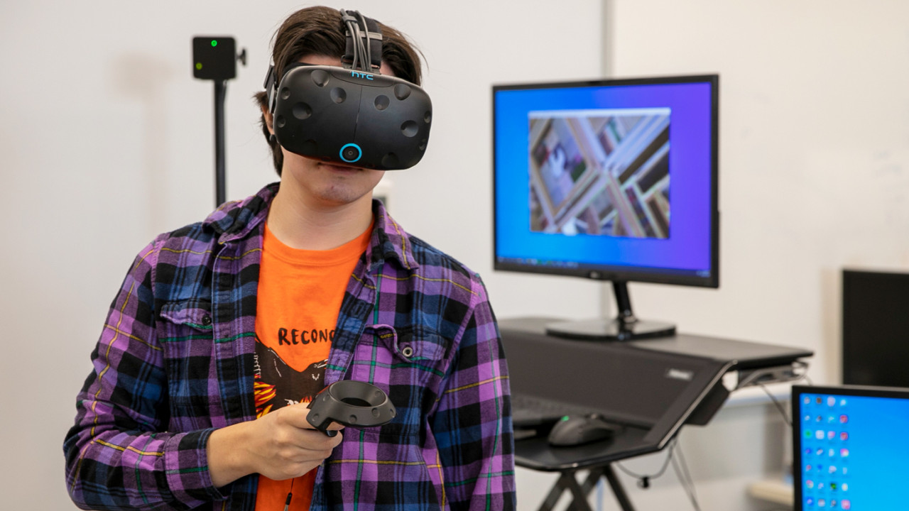 An engineering graphics student wearing a VR  oculus. 