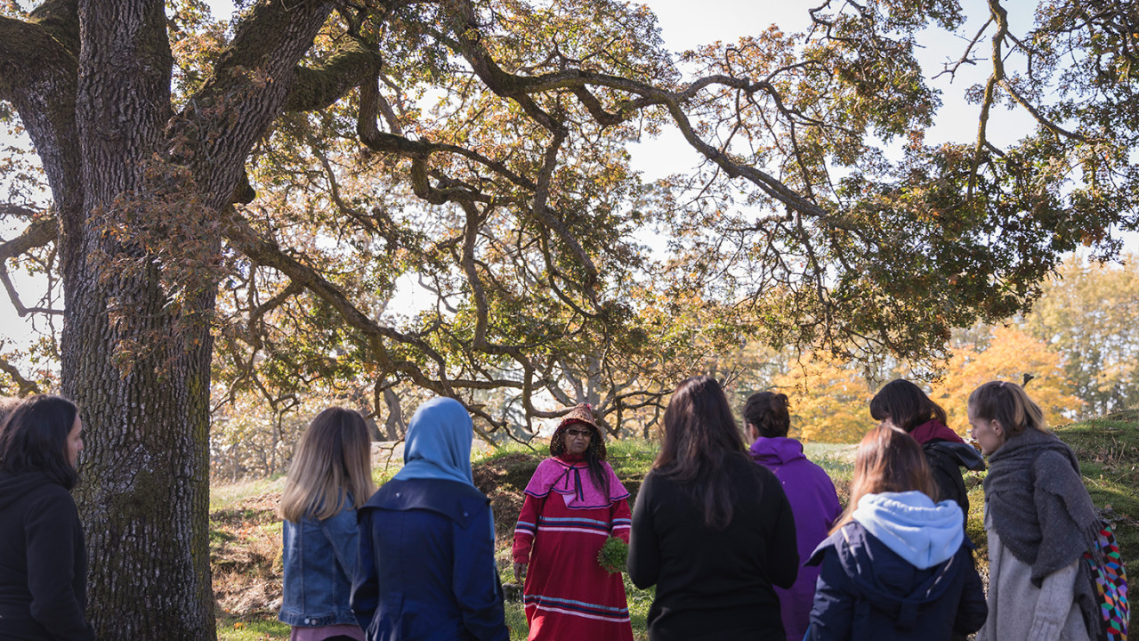 One one demonstrating traditional teachings to students during Camas Pit Cook event