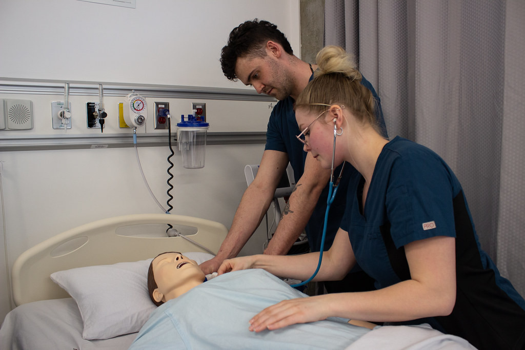 Two student nurses caring for patient