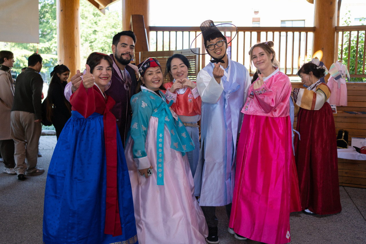 Crowd of attendees gathered, posing in traditional clothing for the picture. 