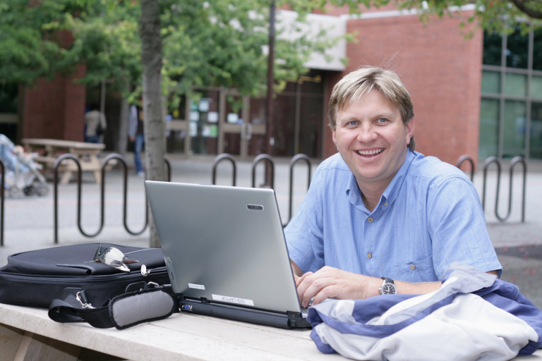 a man studies on a picnic table outside