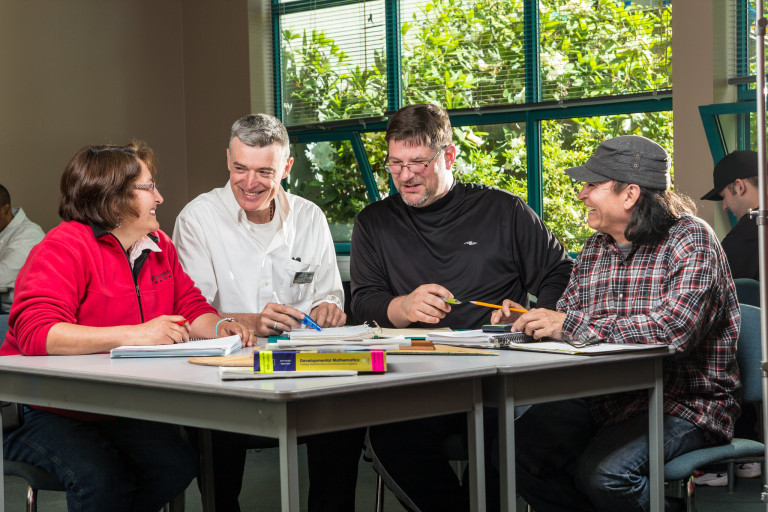 a diverse group of students studies for an English assessment test