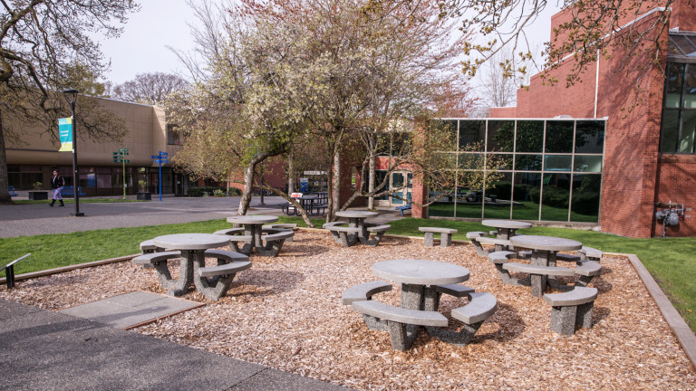 stone tables sit in the middle of an outdoor learning commons