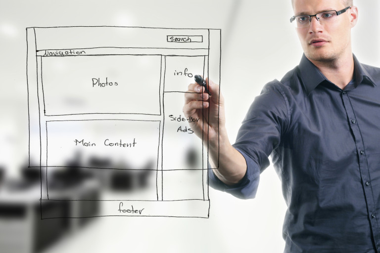 man drawing a storyboard for website