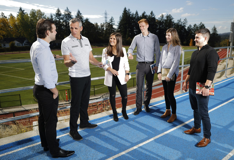 Charles Parkinson standing on the track with a group of students