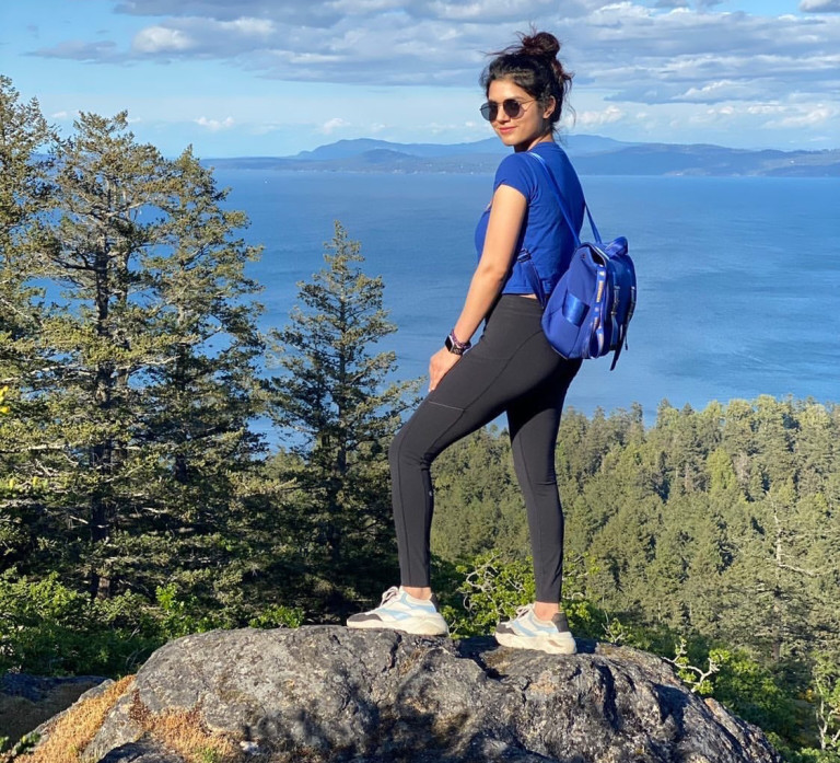 A Camosun student standing on top of a mountain ridge.