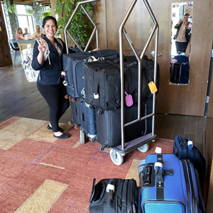 Hospitality Management co-op student taking customers' luggage to their room.  
