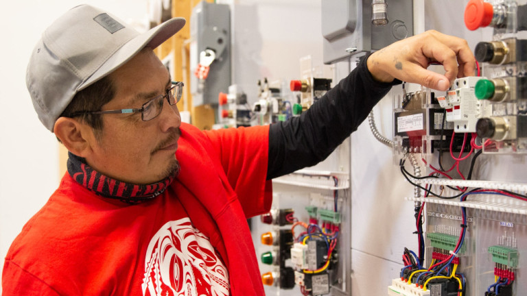 An Indigenous student works on an fuse panel on Electrical workshop.