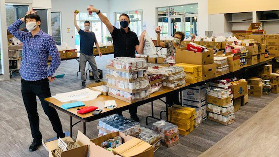 Volunteers packing food hampers stop to strike a pose for the cameras. 