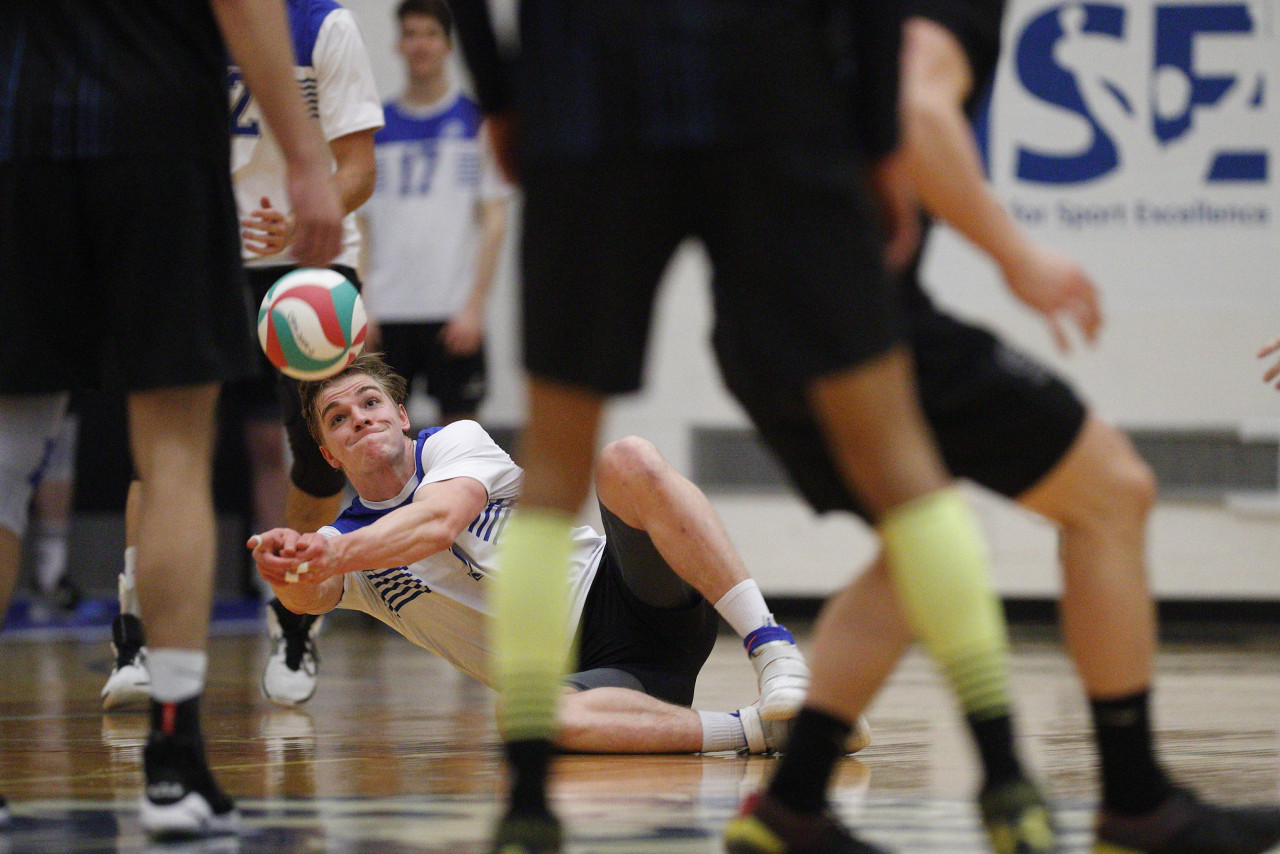 a volleyball play digs deep and stretches' for the ball