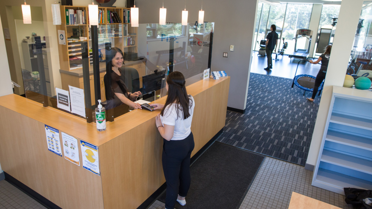 client paying for treatment at aet clinic front desk located at camosun interurban campus
