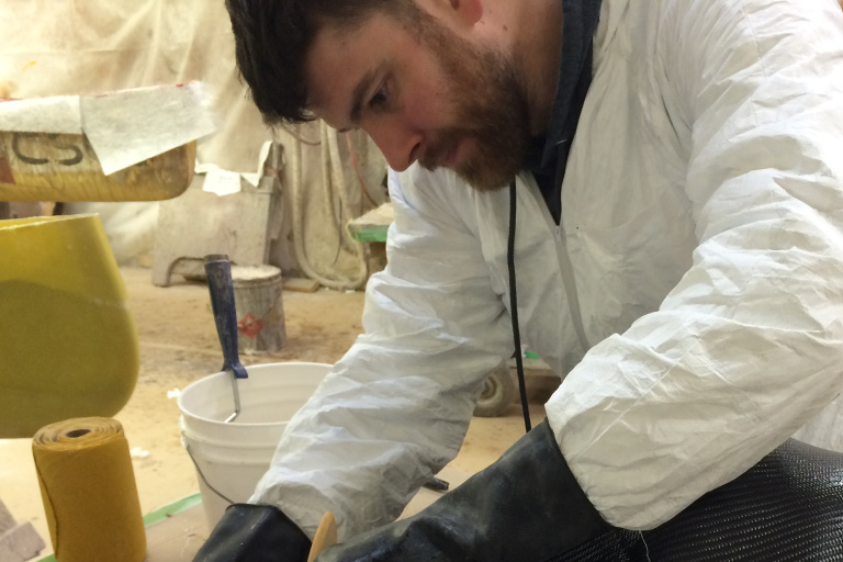 Man wearing white industrial coveralls while working.